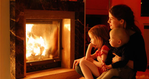 Family enjoying the warmth of a fireplace