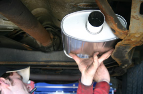 Man working on the muffler part of the-car.