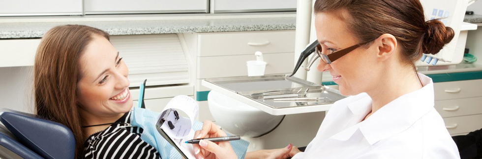 Dentist taking notes with patient