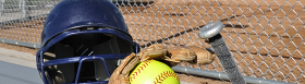 baseball equipment in fron of enclosed baseball field