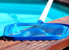 A landing net on the edge of a swimming pool