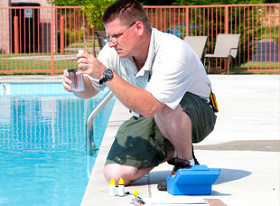 man testing the water in a swiming pool